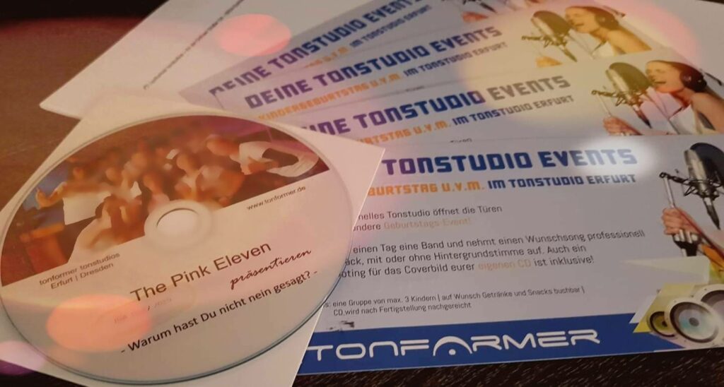 Mehrere TONFORMER-Gutscheine für Tonstudio-Events liegen neben einer bedruckten CD.